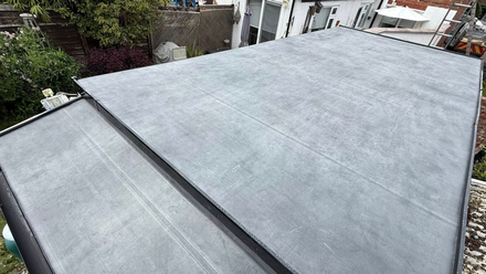 White resin paths split into two around a raised flowerbed, bordered by light-coloured stone walls.