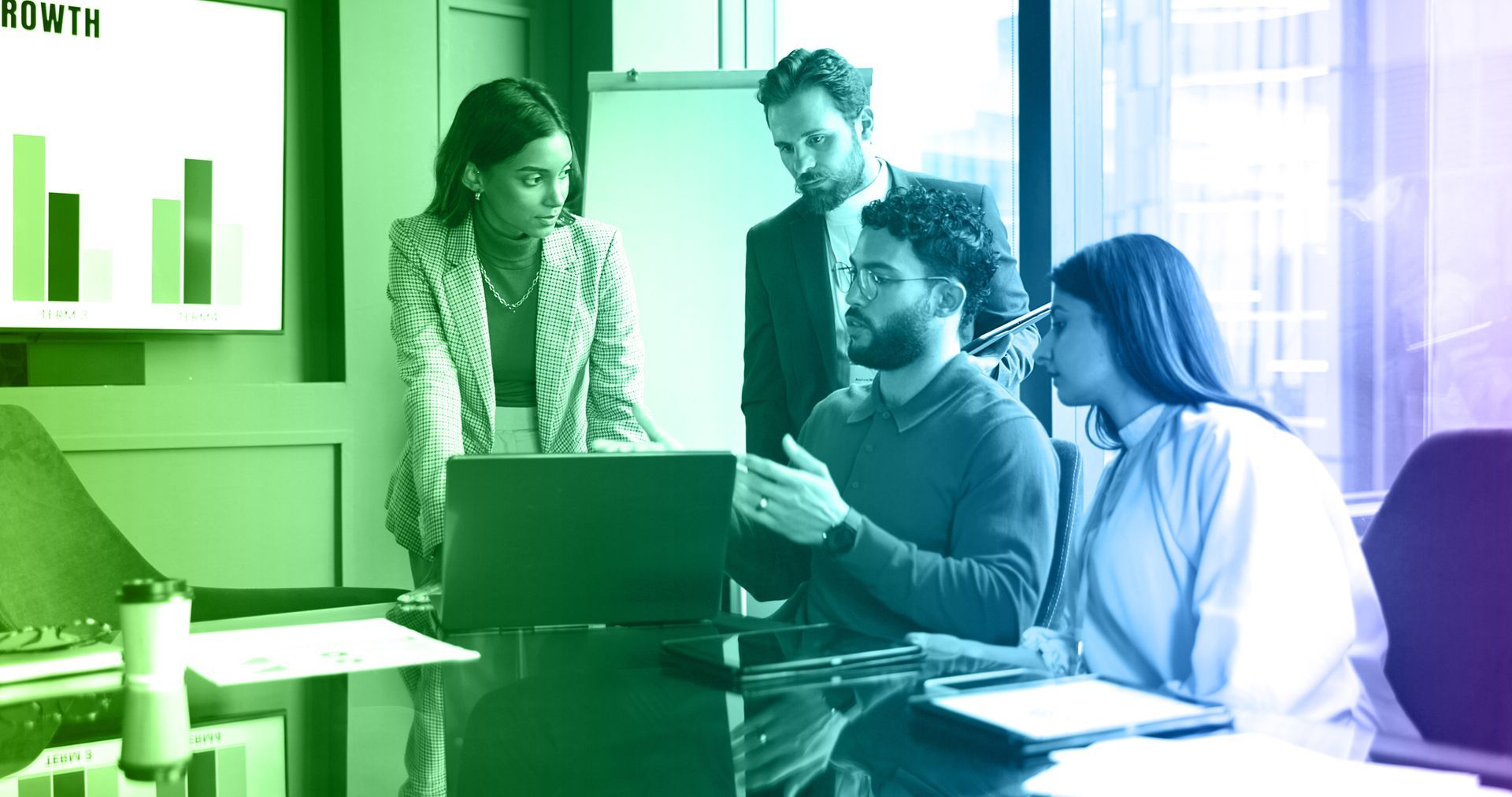 Business team around a laptop in a conference room, analyzing data.