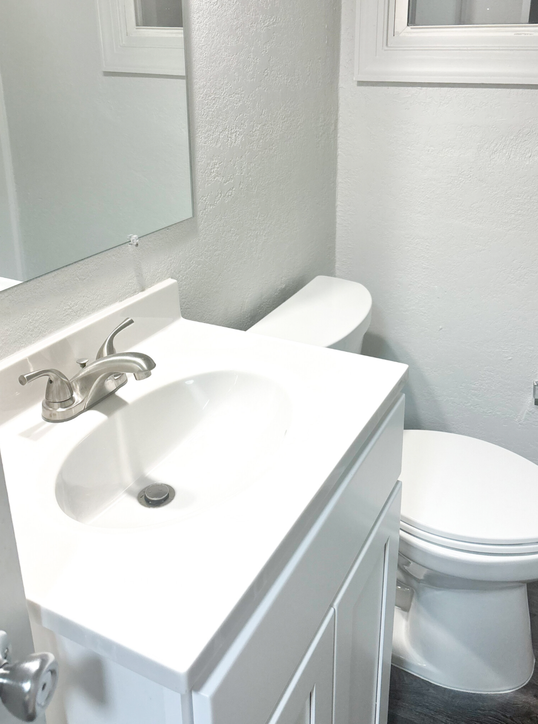 A bathroom with a toilet a sink and a mirror