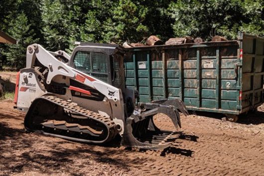 bobcat machine in forest clearing