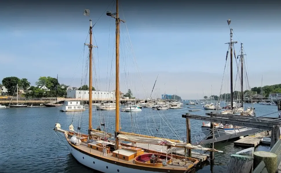 A sailboat is docked in a harbor next to a dock.