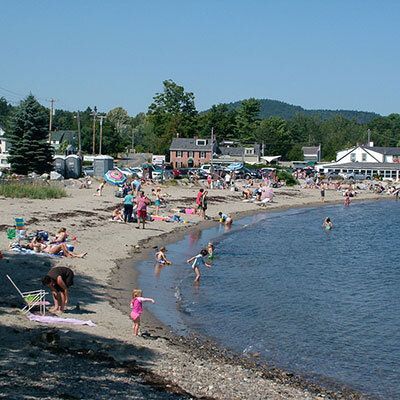 A beach with a lot of people playing in the water