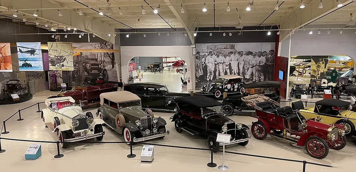 A museum filled with lots of old cars and motorcycles.