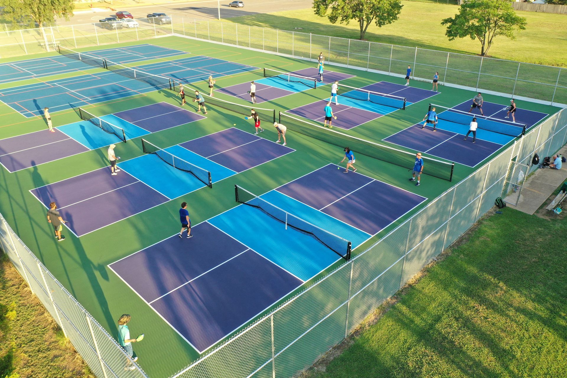 A group of people are playing tennis on a tennis court.