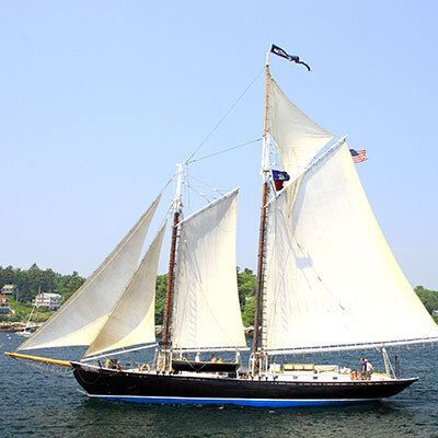 A large sailboat is floating on top of a body of water