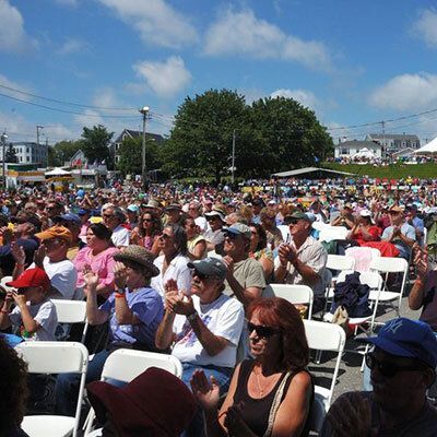 A large crowd of people are sitting in chairs and clapping