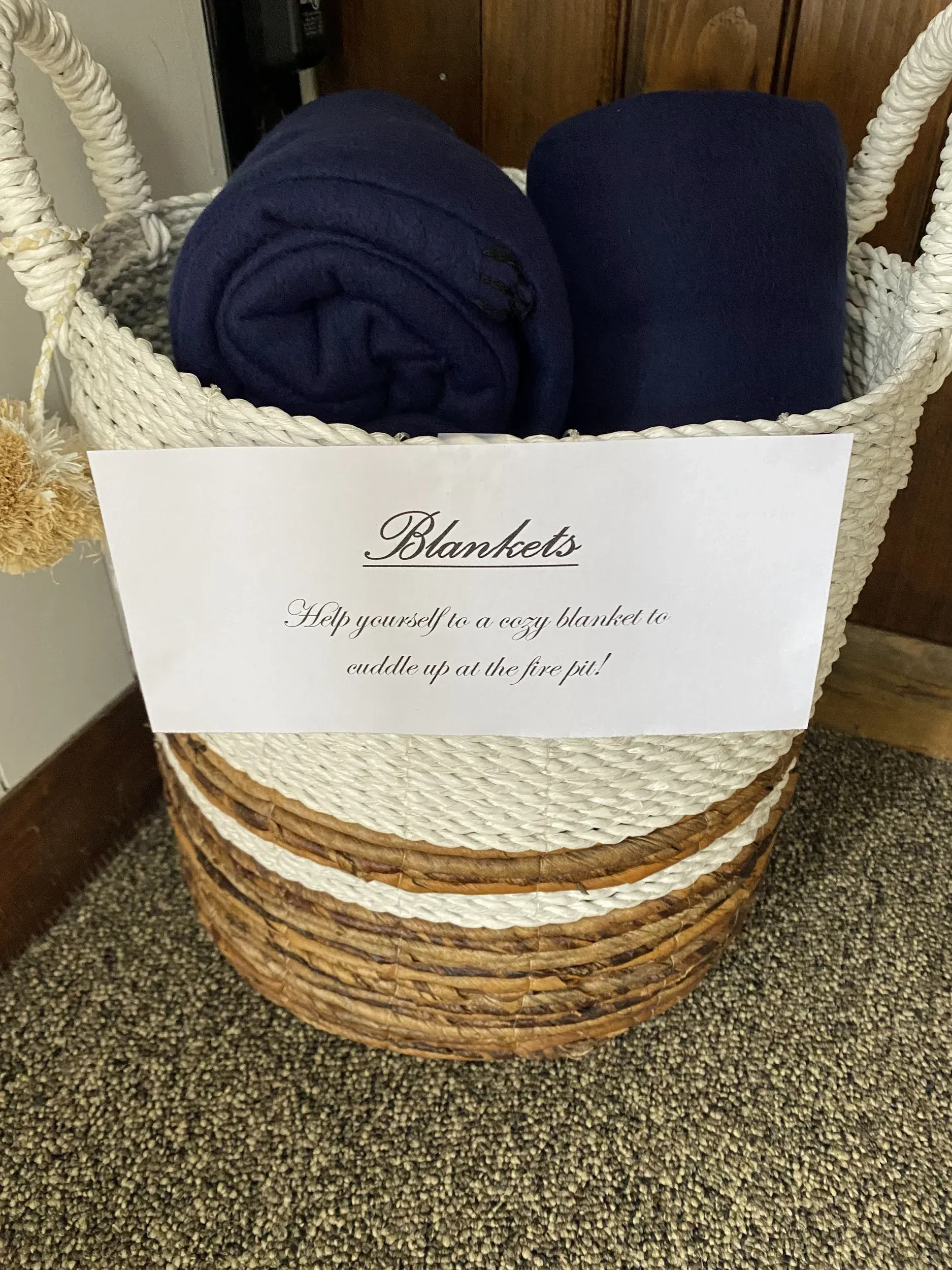 A basket filled with blankets and a sign that says `` blankets ''.
