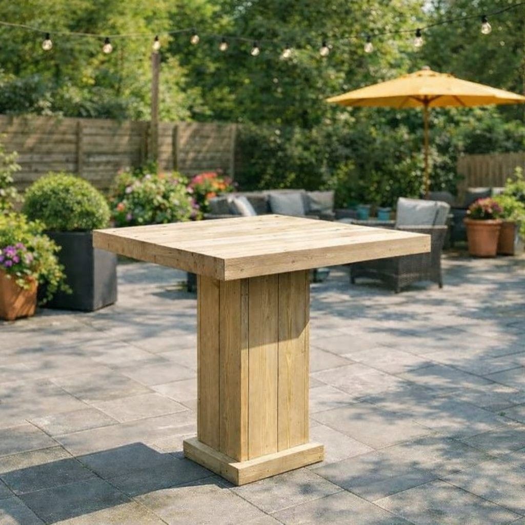 Een houten statafel op een zonnig terras met ligstoelen, een parasol en potplanten.