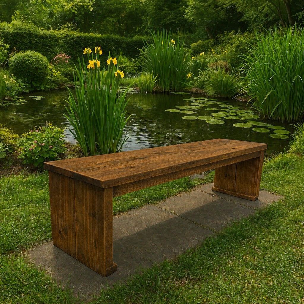 Bruin houten bankje bij een vijver in een weelderige groene tuin met gele bloemen.