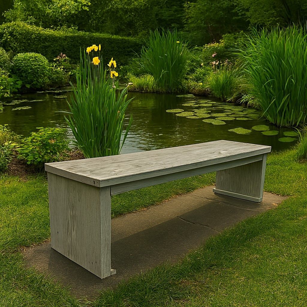 Grijs houten bankje naast een tuinvijver met gele bloemen en weelderig groen.