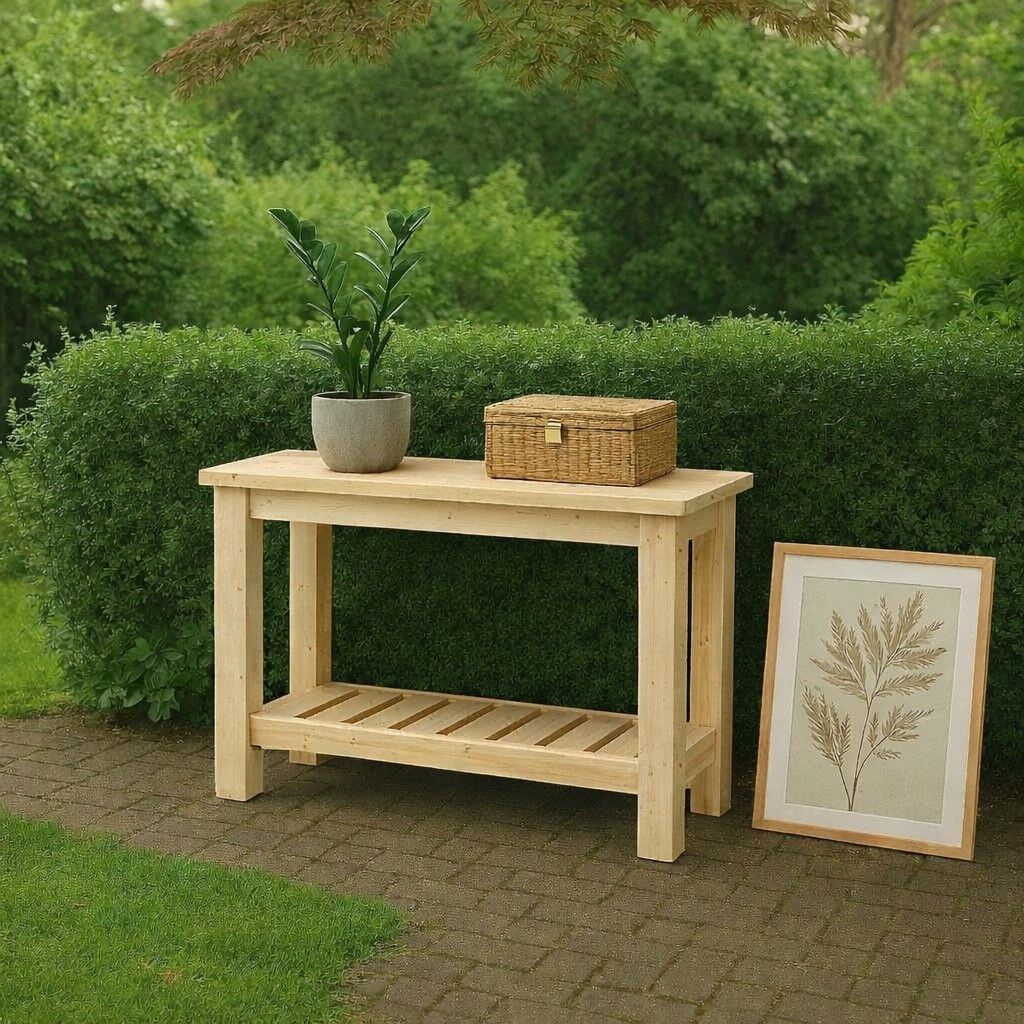 Houten consoletafel buiten met een potplant, een rieten mand en een ingelijste bladprint bij een groene haag.