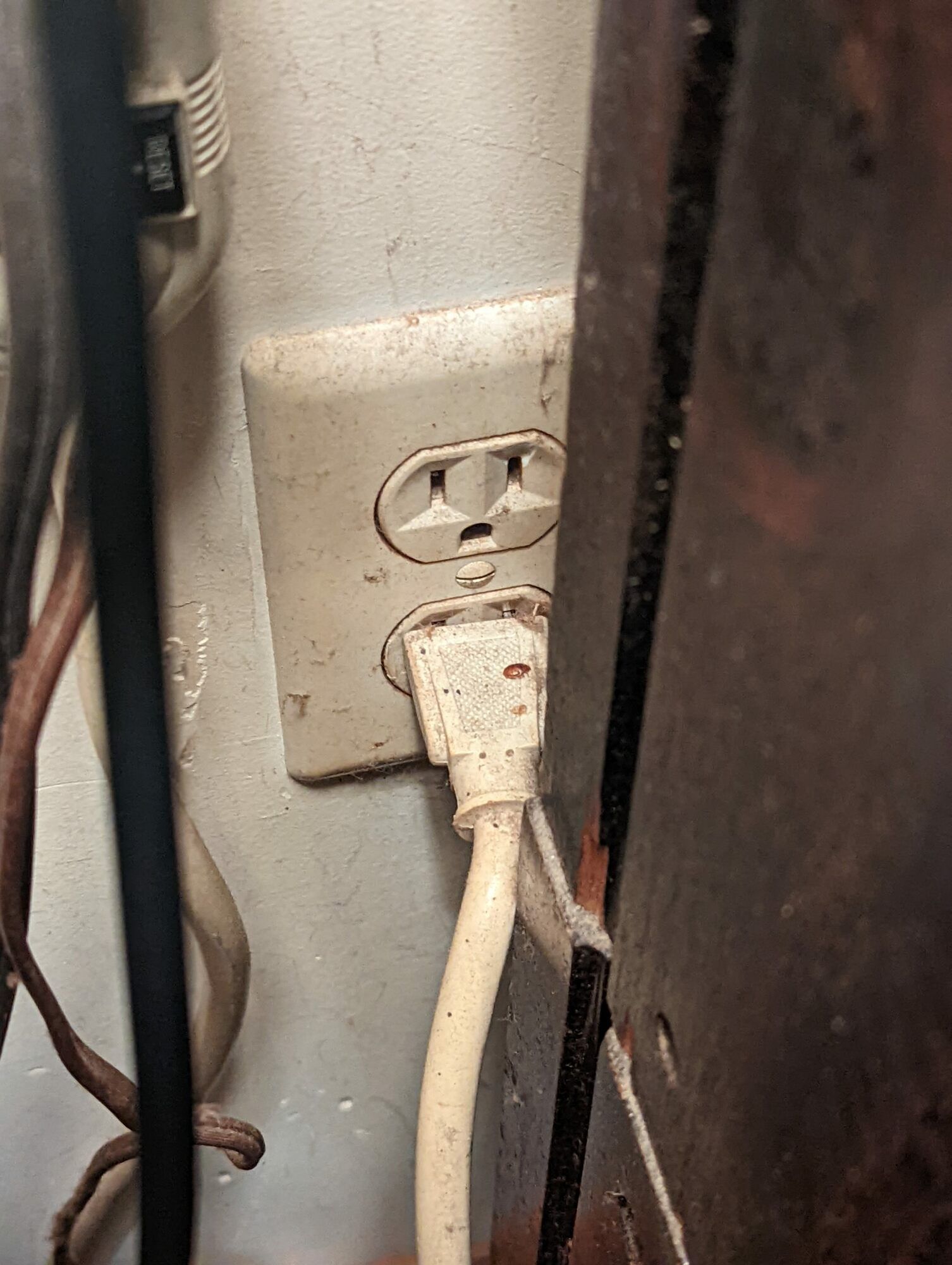 A close up of an electrical outlet with a cord plugged into it.