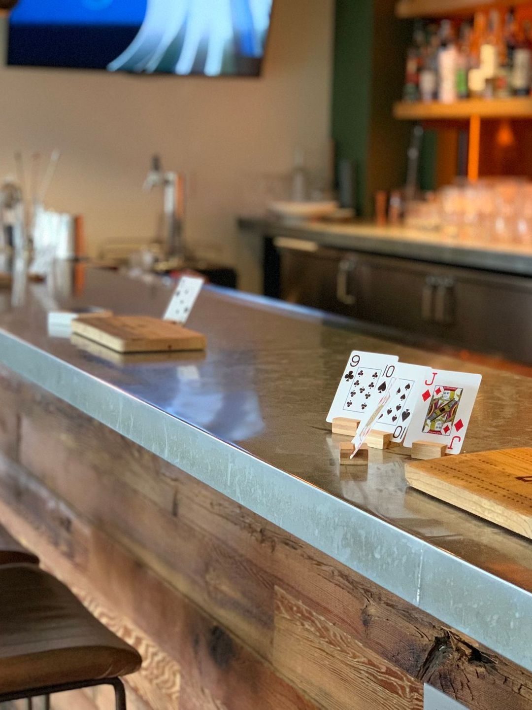 a bar with a wooden counter top and playing cards on it