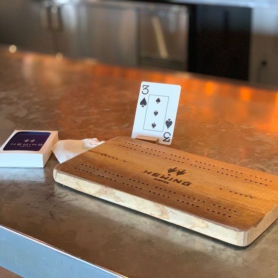 a wooden cribbage board with a playing card on top of it