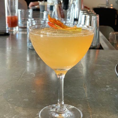 a close up of a cocktail in a martini glass on a bar .