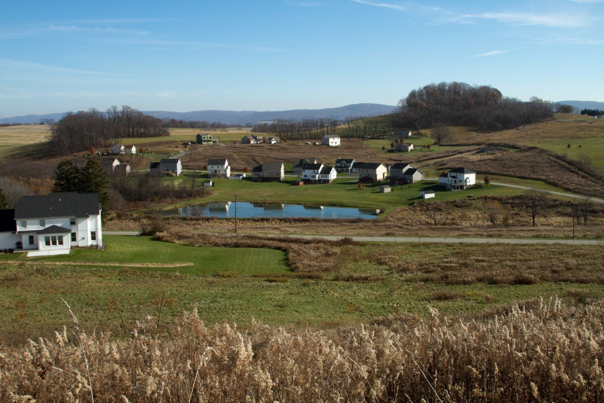 A residential area with houses and a pond in the middle
