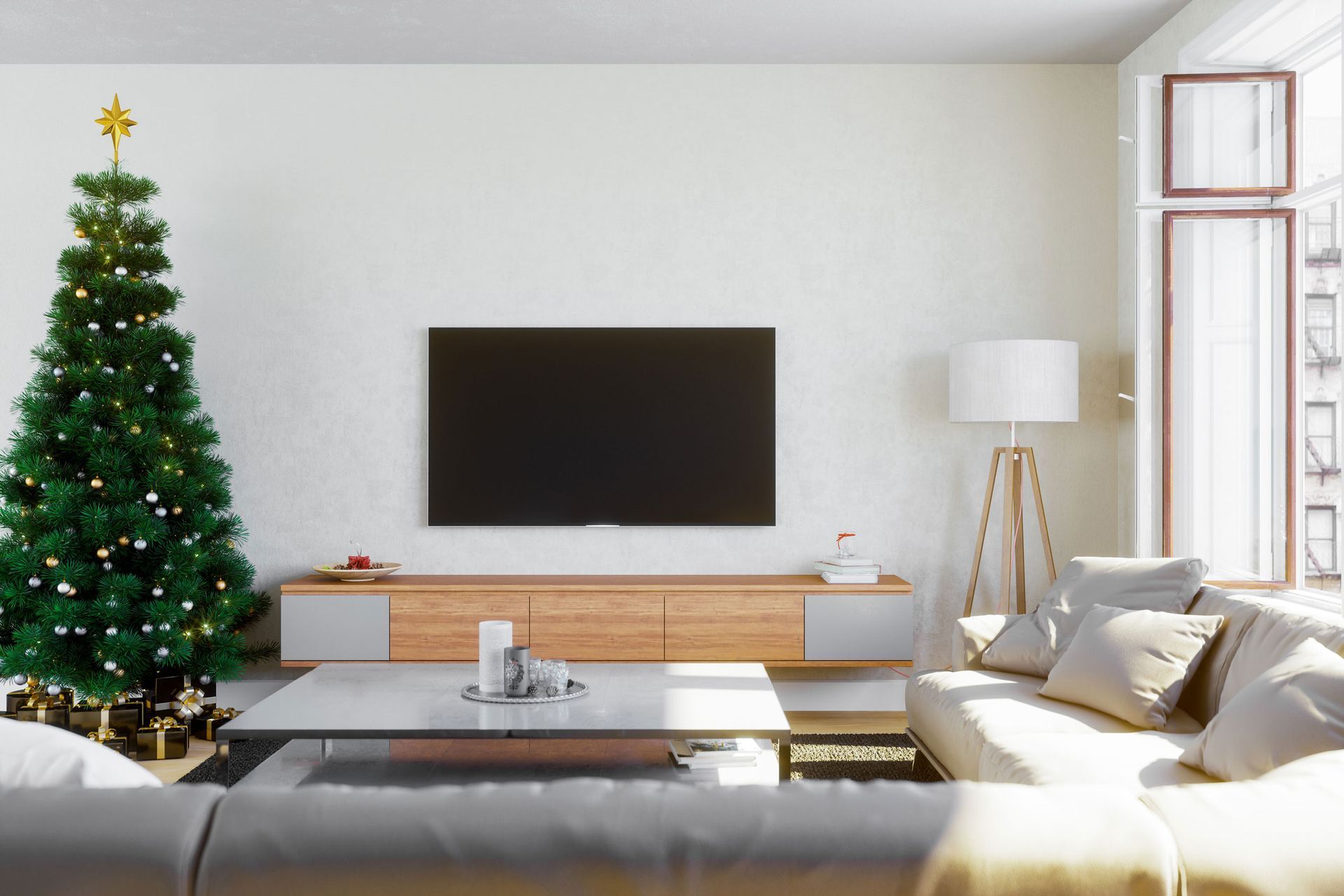 A living room with a christmas tree and a flat screen tv.