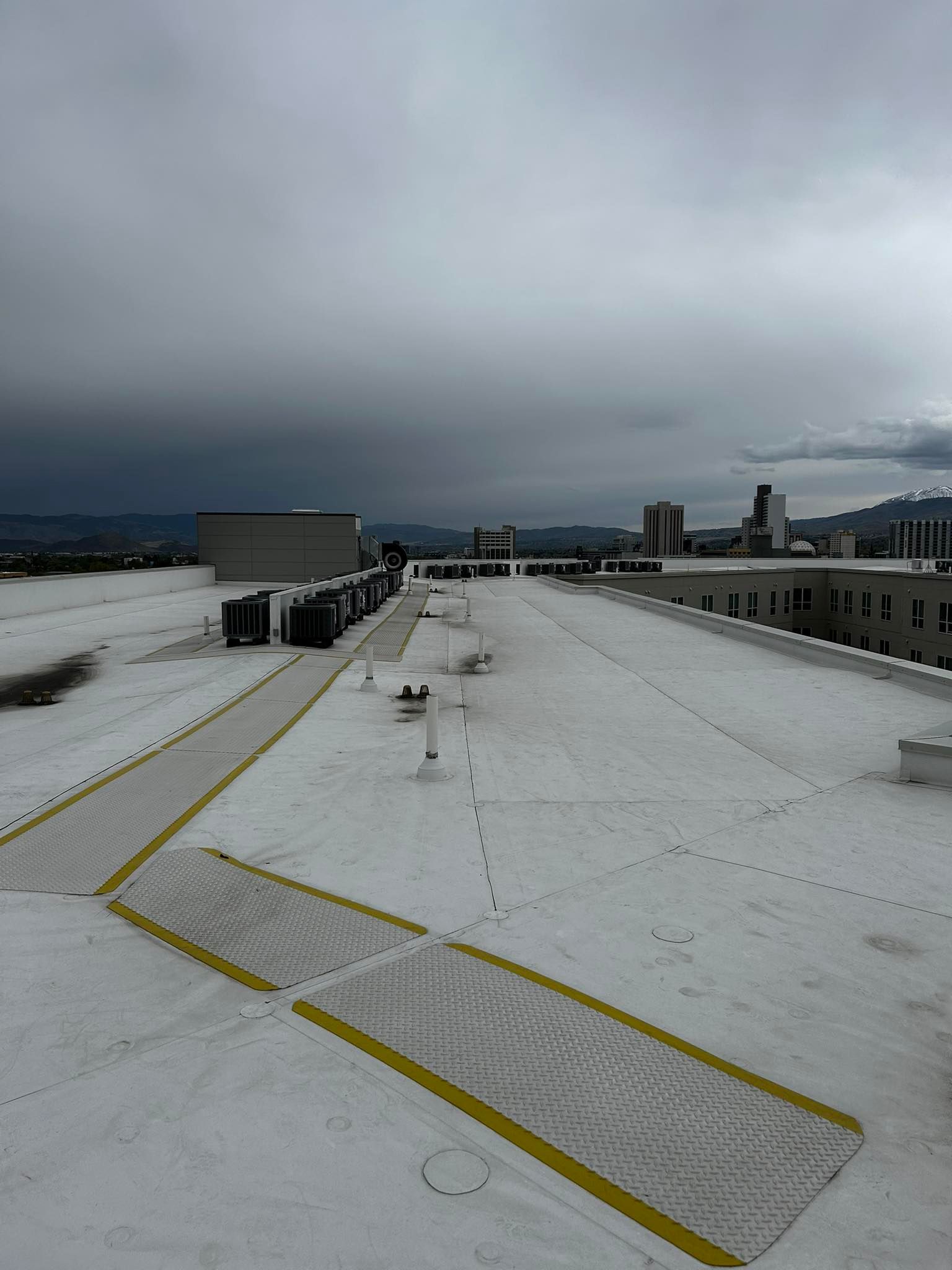 An aerial view of a snowy rooftop with a yellow stripe on it.