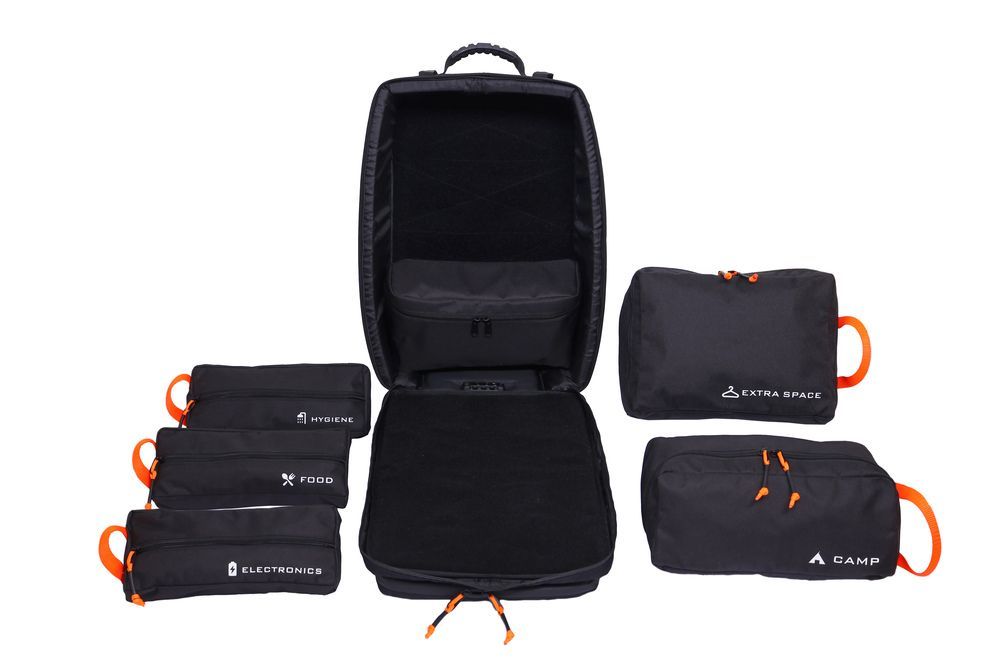 Czarna torba z pomarańczowymi uchwytami leży na białej powierzchni.