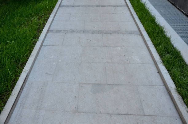 A concrete sidewalk is built on top of bare ground.