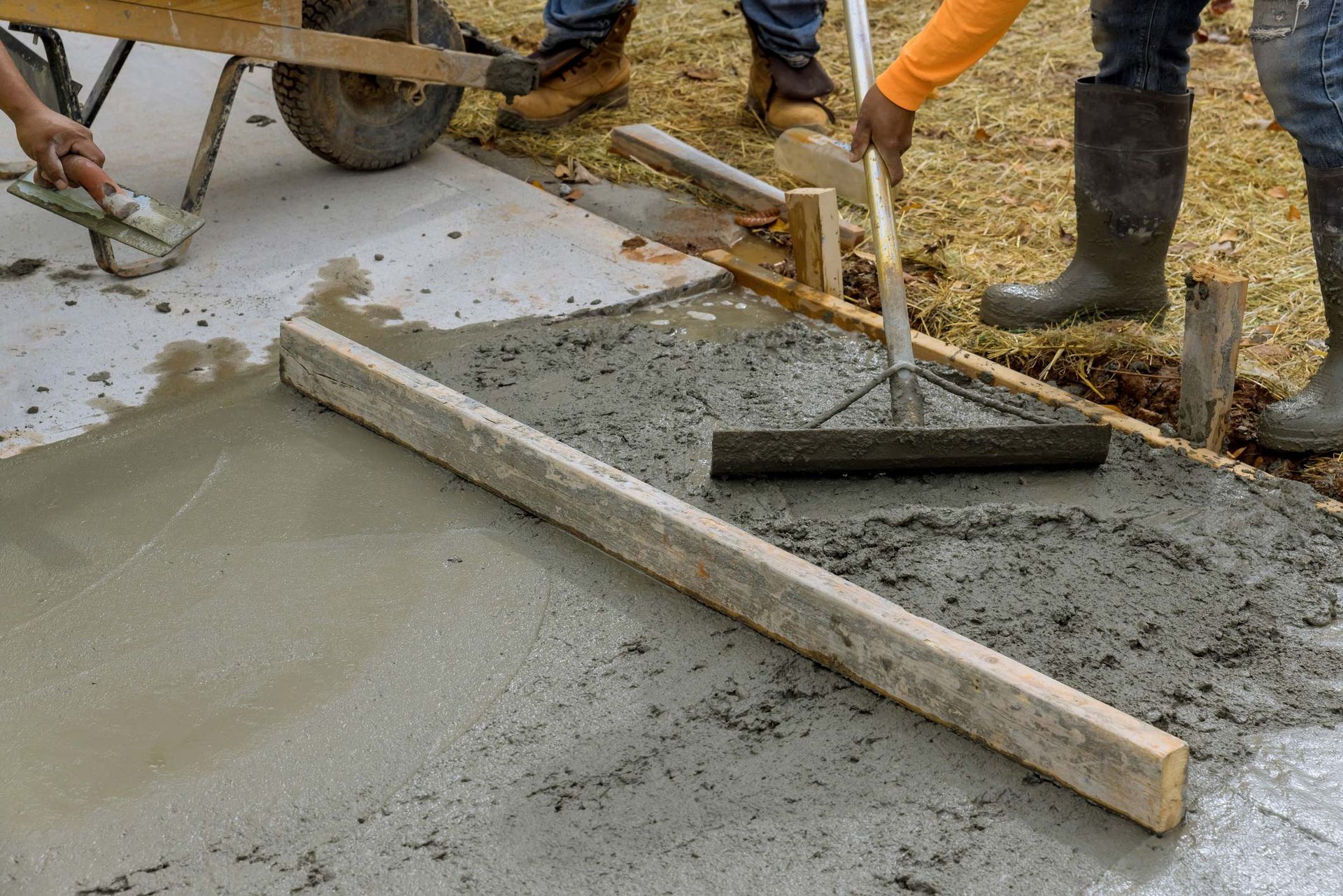 Concrete service worker leveling a fresh concrete surface.