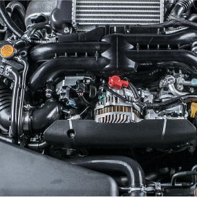 Close-up of a car engine, mostly black with some silver and yellow details, featuring a radiator and various mechanical components. | RX Automotive