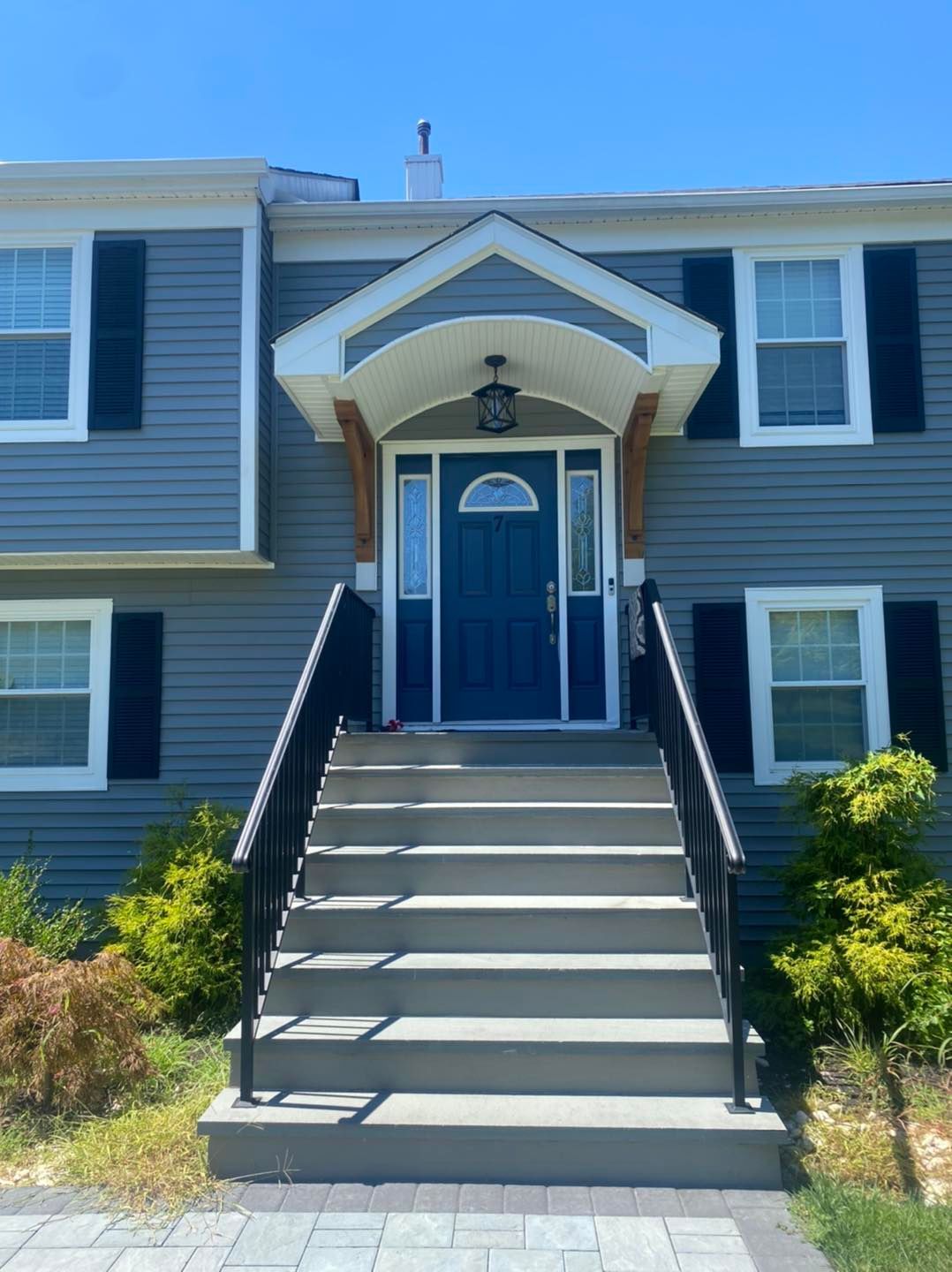 The front of a house with stairs leading up to the front door.