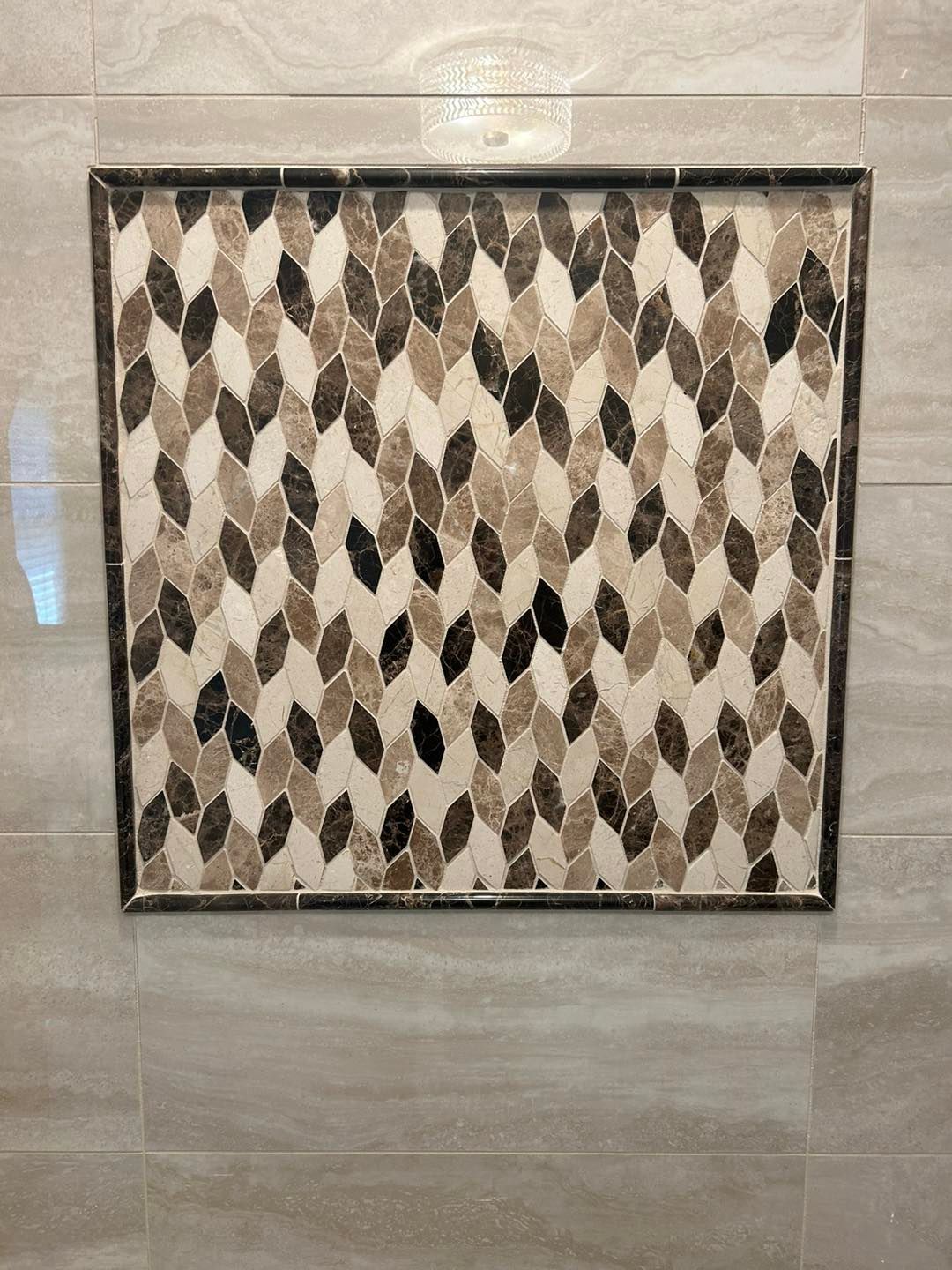 A picture of a mosaic on a wall in a bathroom.