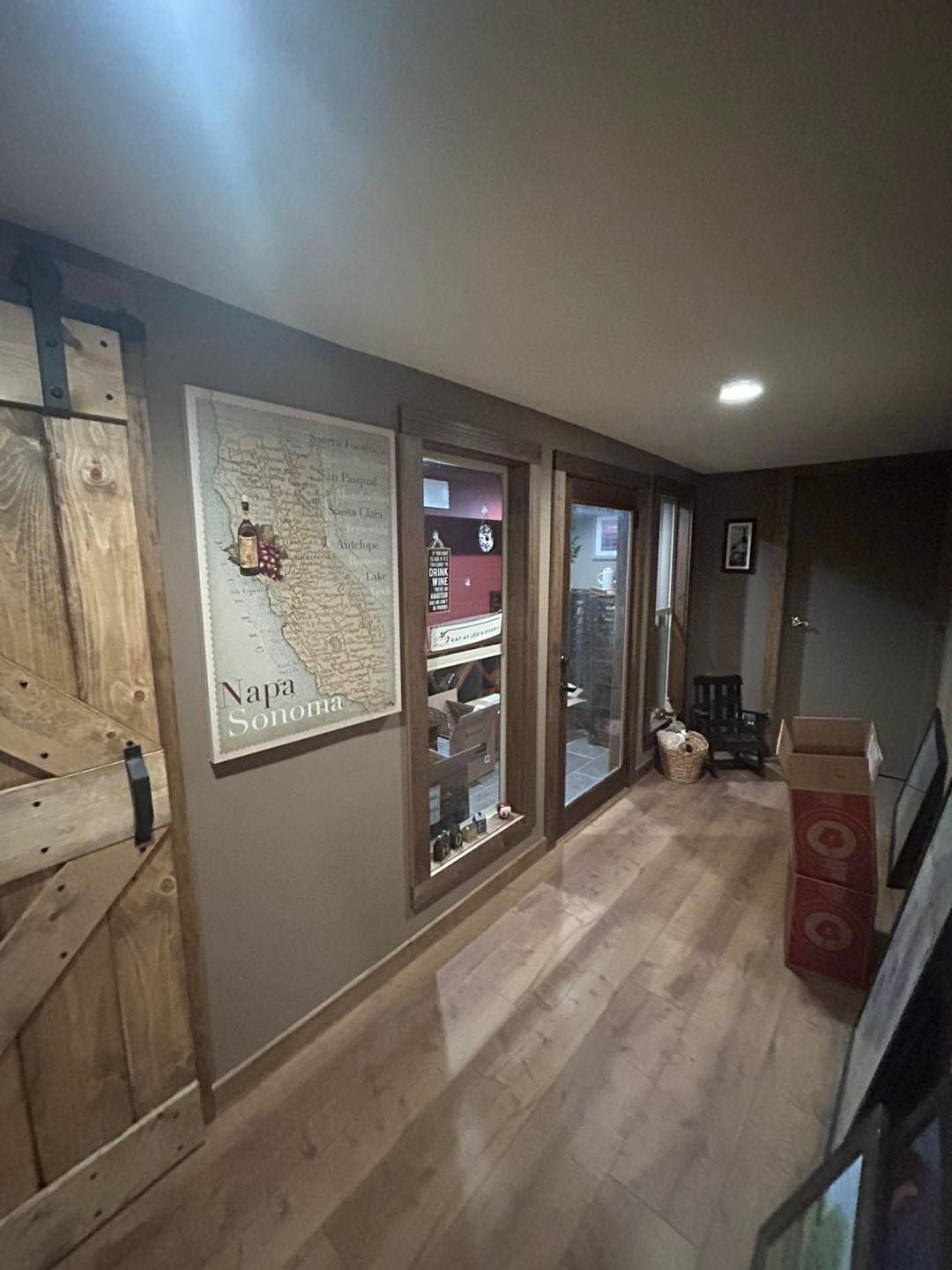 A hallway with hardwood floors and a map on the wall.