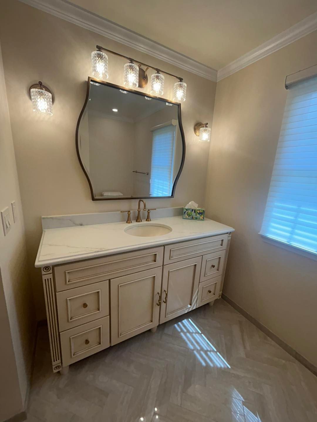 A bathroom with a sink , mirror and cabinets.
