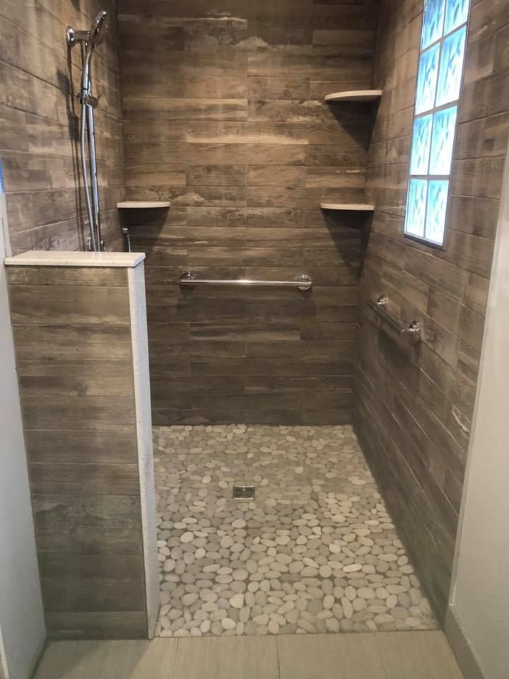 A bathroom with a walk in shower and a window.