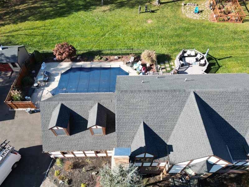 An aerial view of a house with a large pool in the backyard