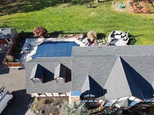 An aerial view of a house with a large pool in the backyard