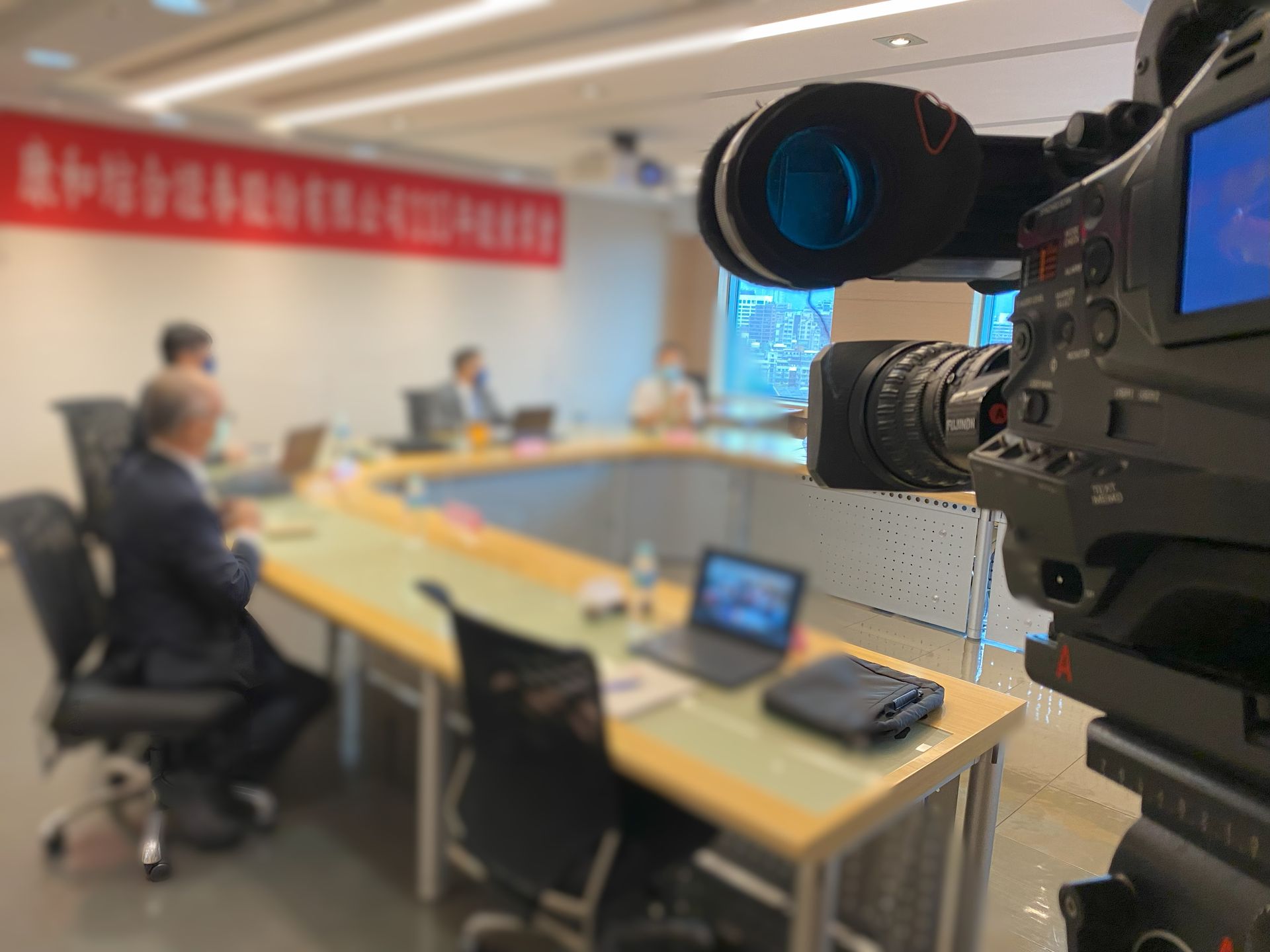 專業攝影機正在拍攝會議室中的一場會議。