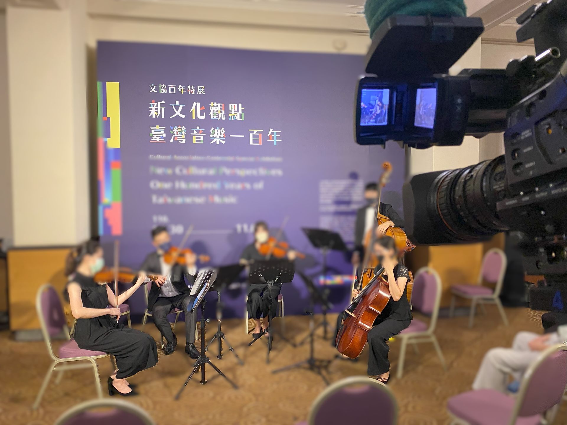 弦樂四重奏在一次文化活動的舞台上表演，並被攝影機拍下來。