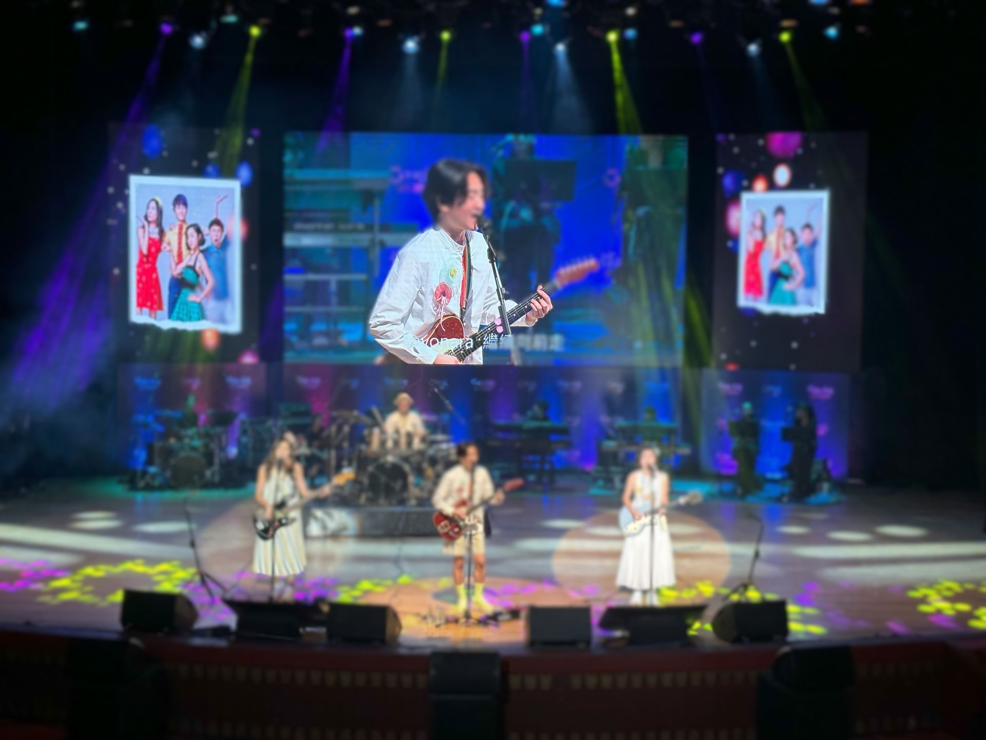 舞台上有歌手、樂隊和顯示圖像的螢幕進行音樂表演。