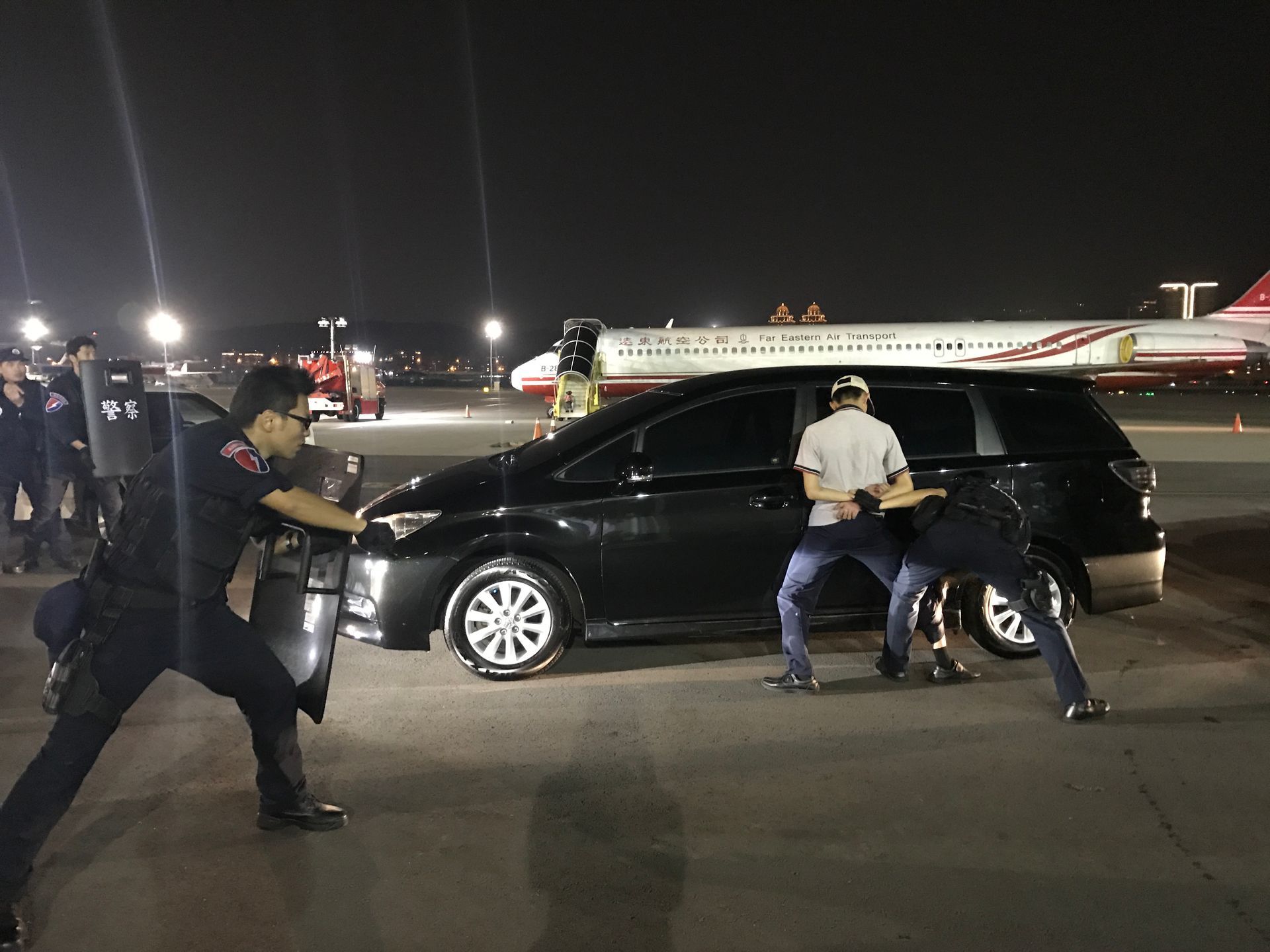 夜間，警方在一輛汽車和一架停放的飛機附近逮捕嫌犯。