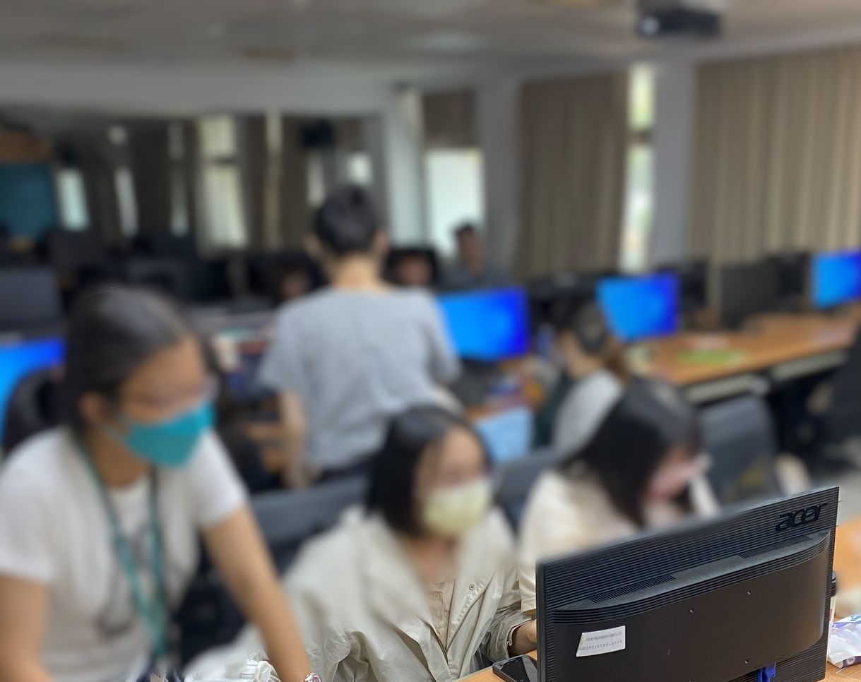 學生們戴著口罩在電腦實驗室操作電腦。
