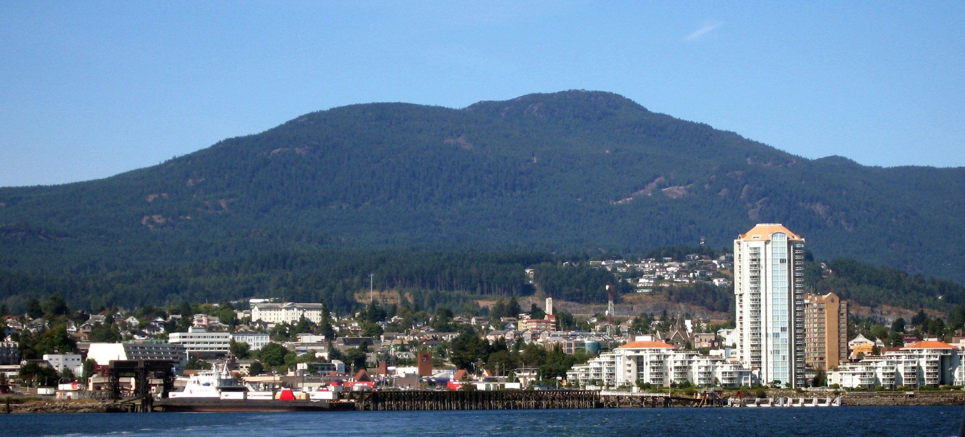 A city with a mountain in the background and a large building in the foreground