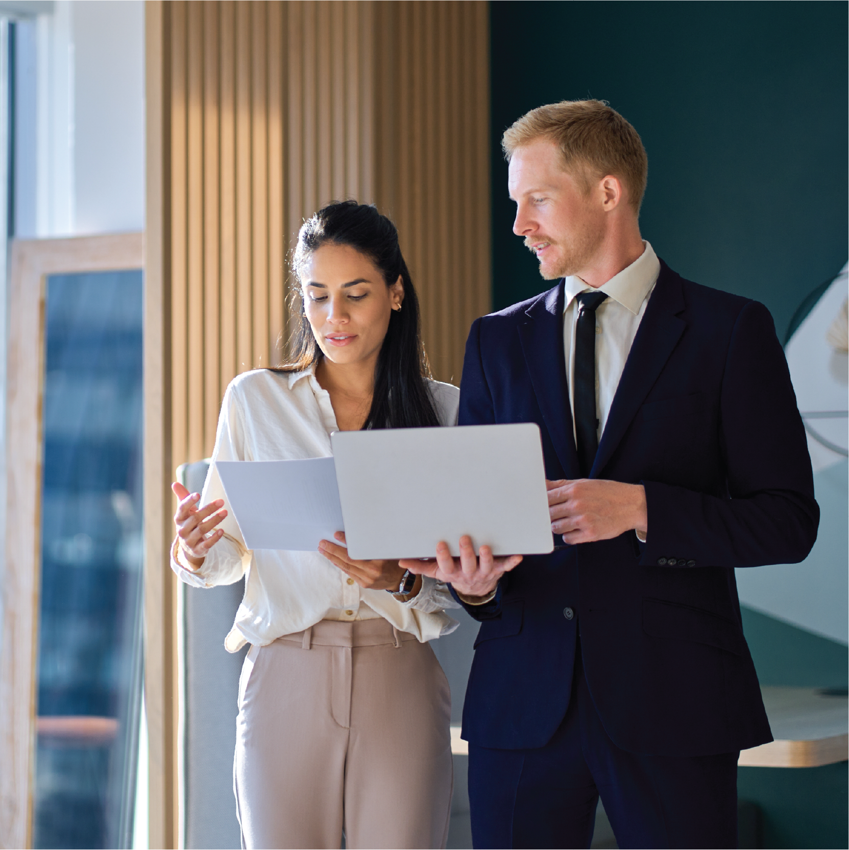 A man and a woman are looking at a laptop together.