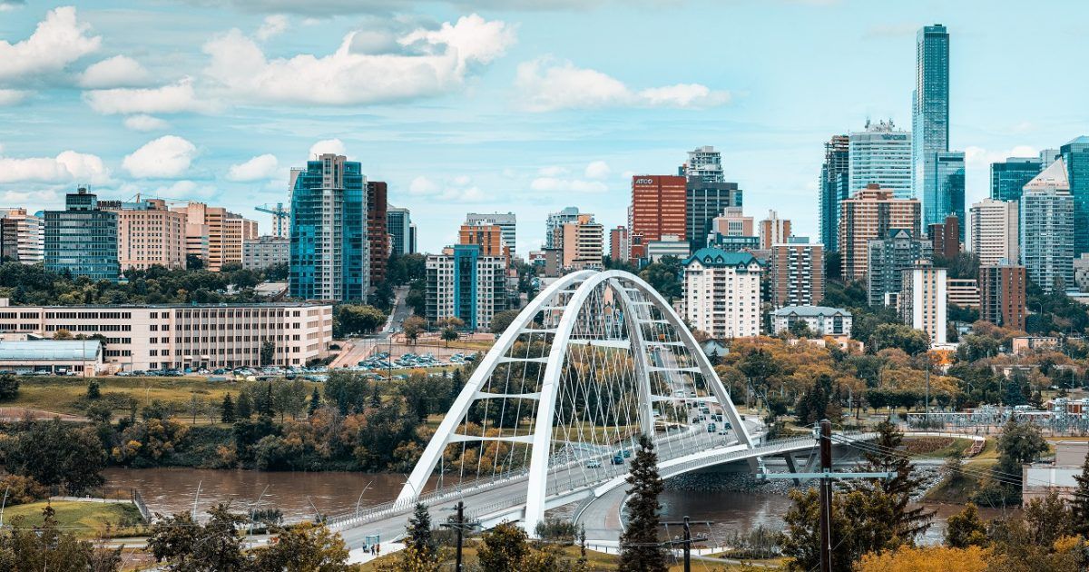 A bridge over a river in a city with a city skyline in the background.