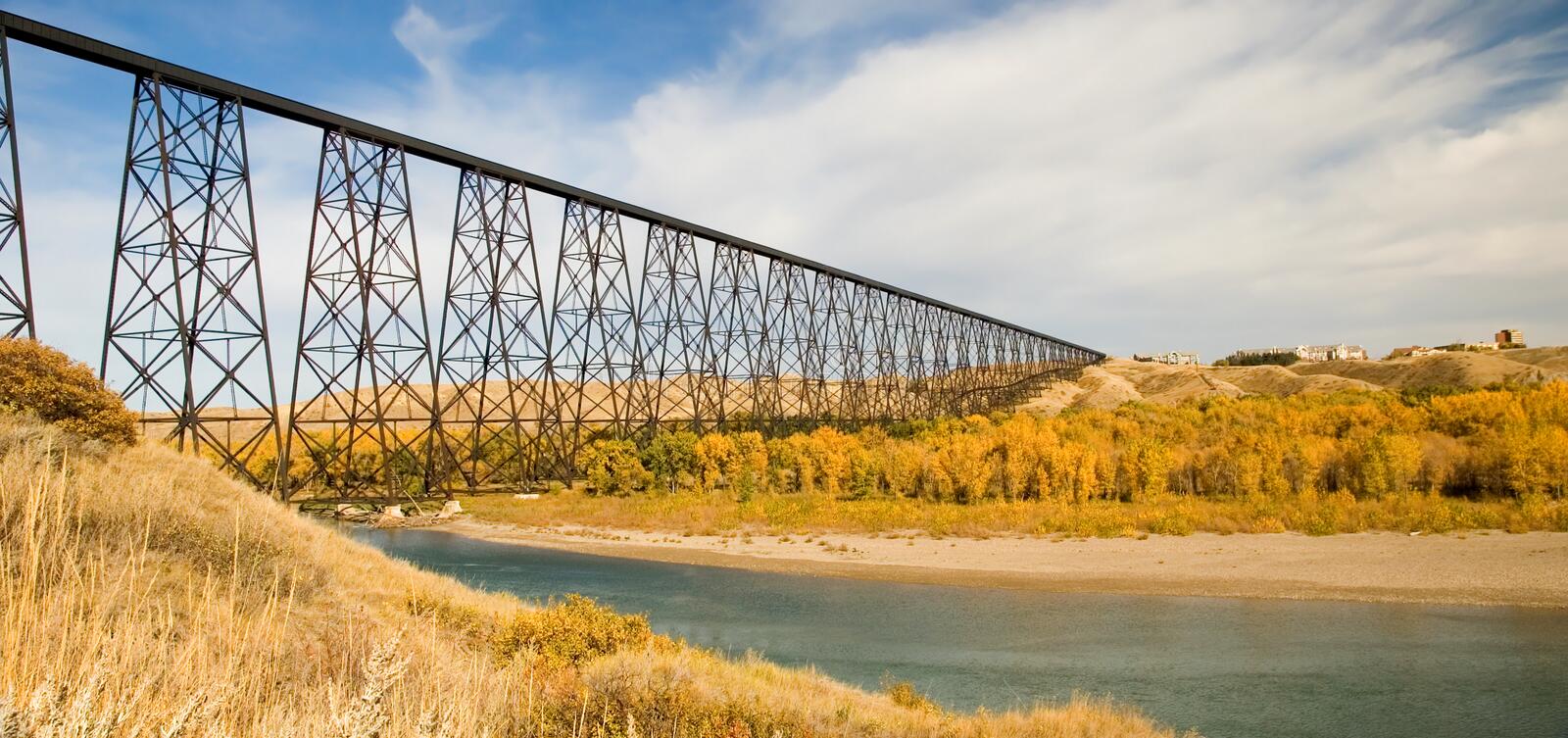 A bridge over a river in the middle of a field.