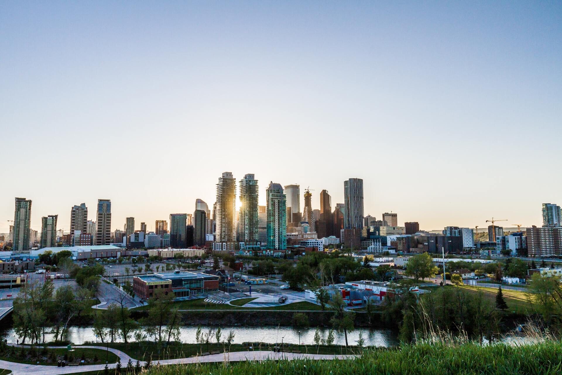 An aerial view of a city skyline with a river in the foreground.