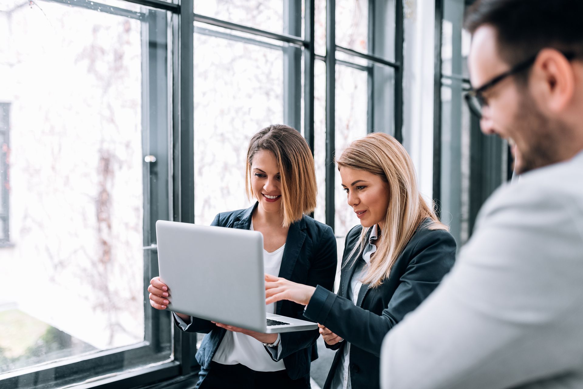 A group of business people are looking at a laptop computer.