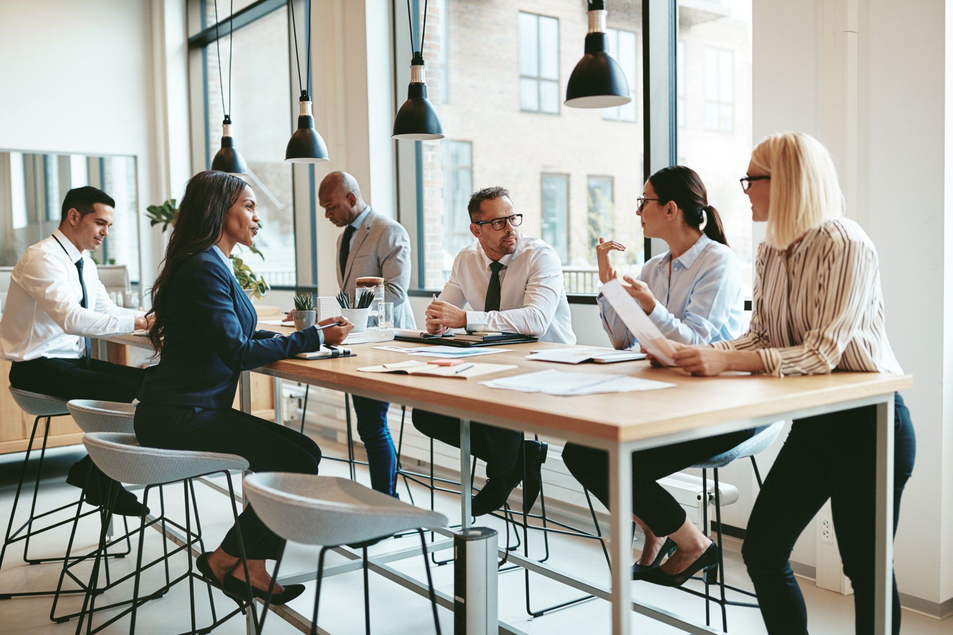 A group of business people are sitting around a table having a meeting.