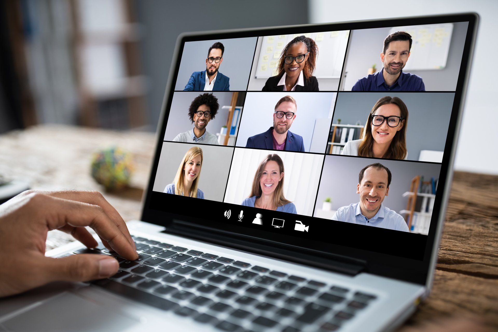 A person is using a laptop computer to have a video call with a group of people.