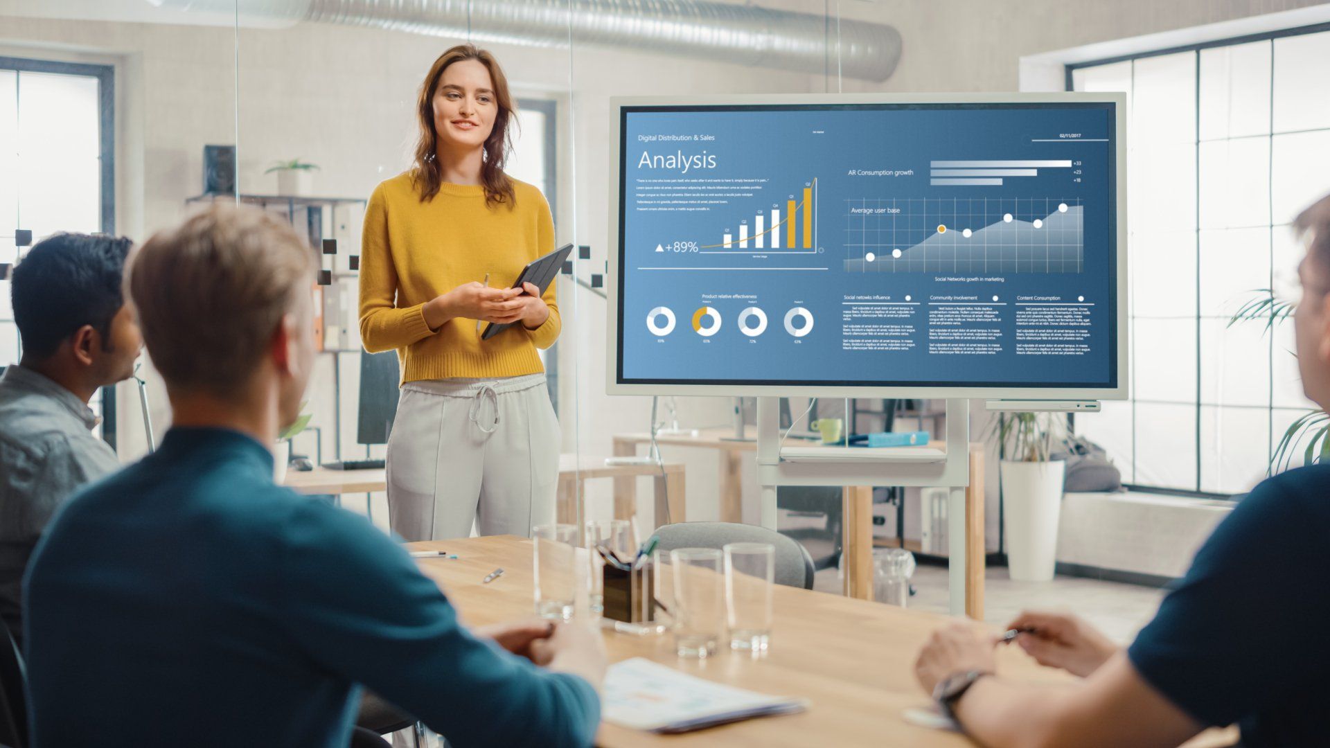 A woman is giving a presentation to a group of people in a conference room.