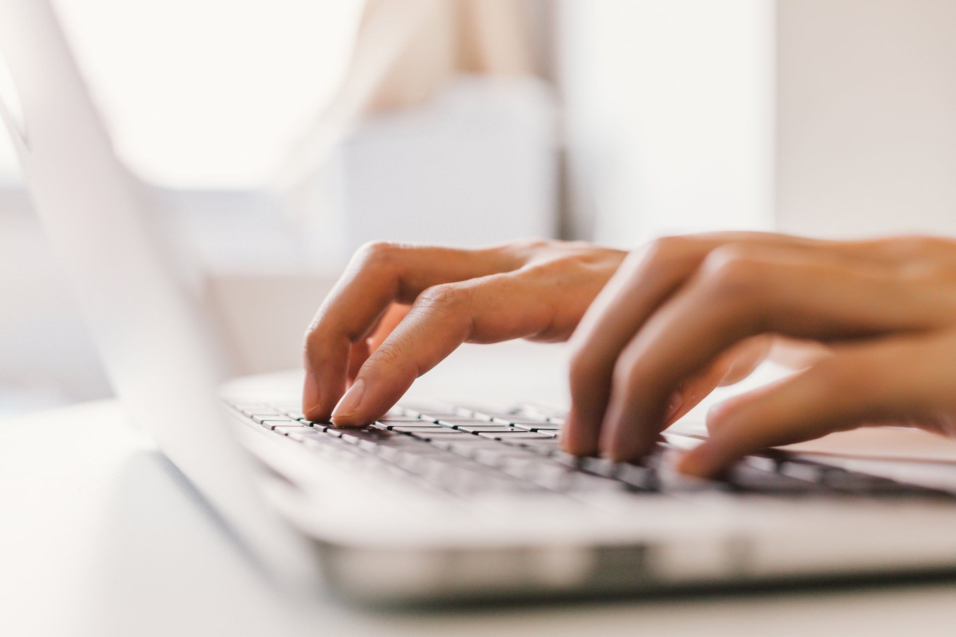 A person is typing on a laptop computer.