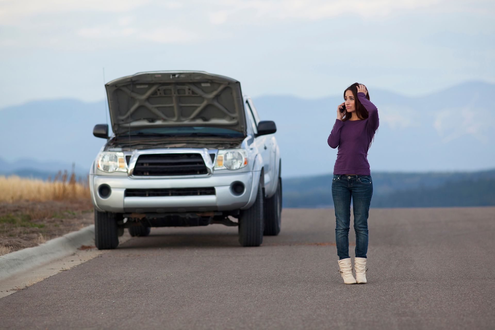 Stressed driver reaching out for emergency roadside help.