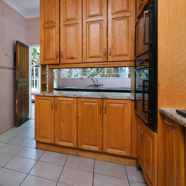 Kitchen with white cabinets, black refrigerator, and countertop with small appliances.